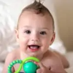 baby smiling holding toy