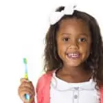 little girl holding toothbrush